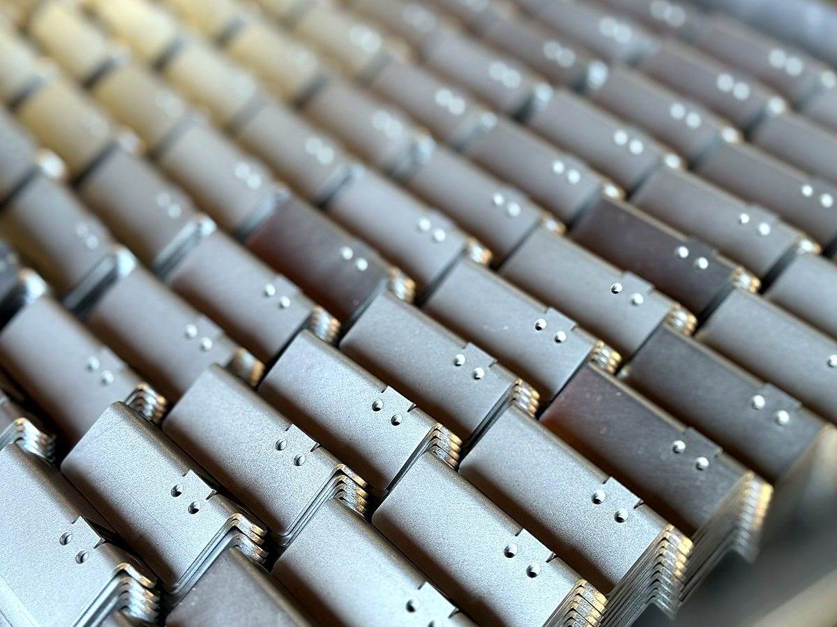 Rows of identical bent aluminum brackets made at ACP Waterjet
