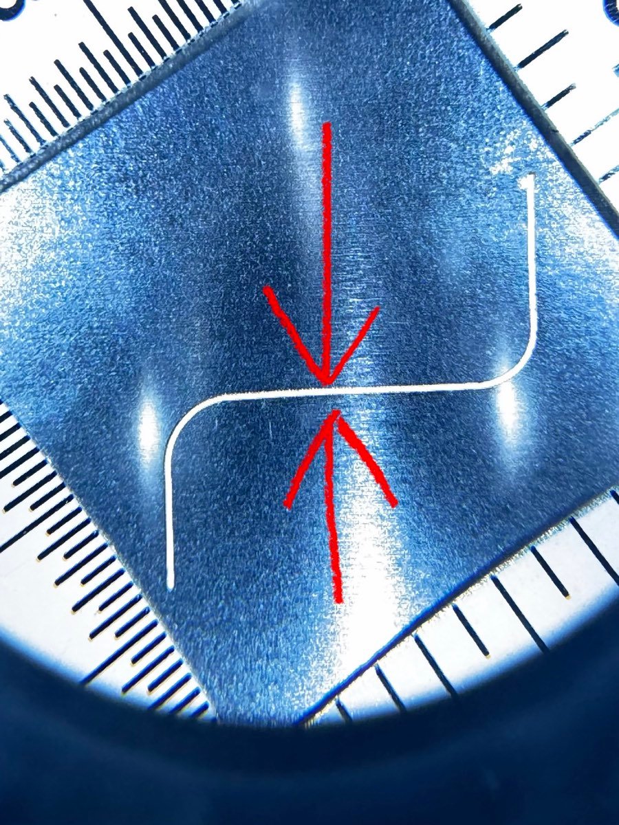 Formed bend radius inspected under a measuring loupe against a rule at ACP Waterjet