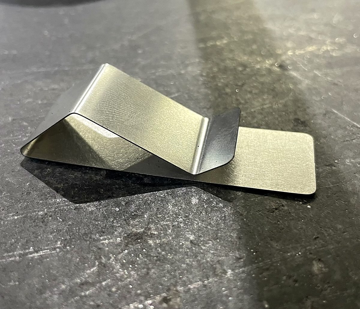 Bent stainless steel part showing a smooth formed curve at ACP Waterjet