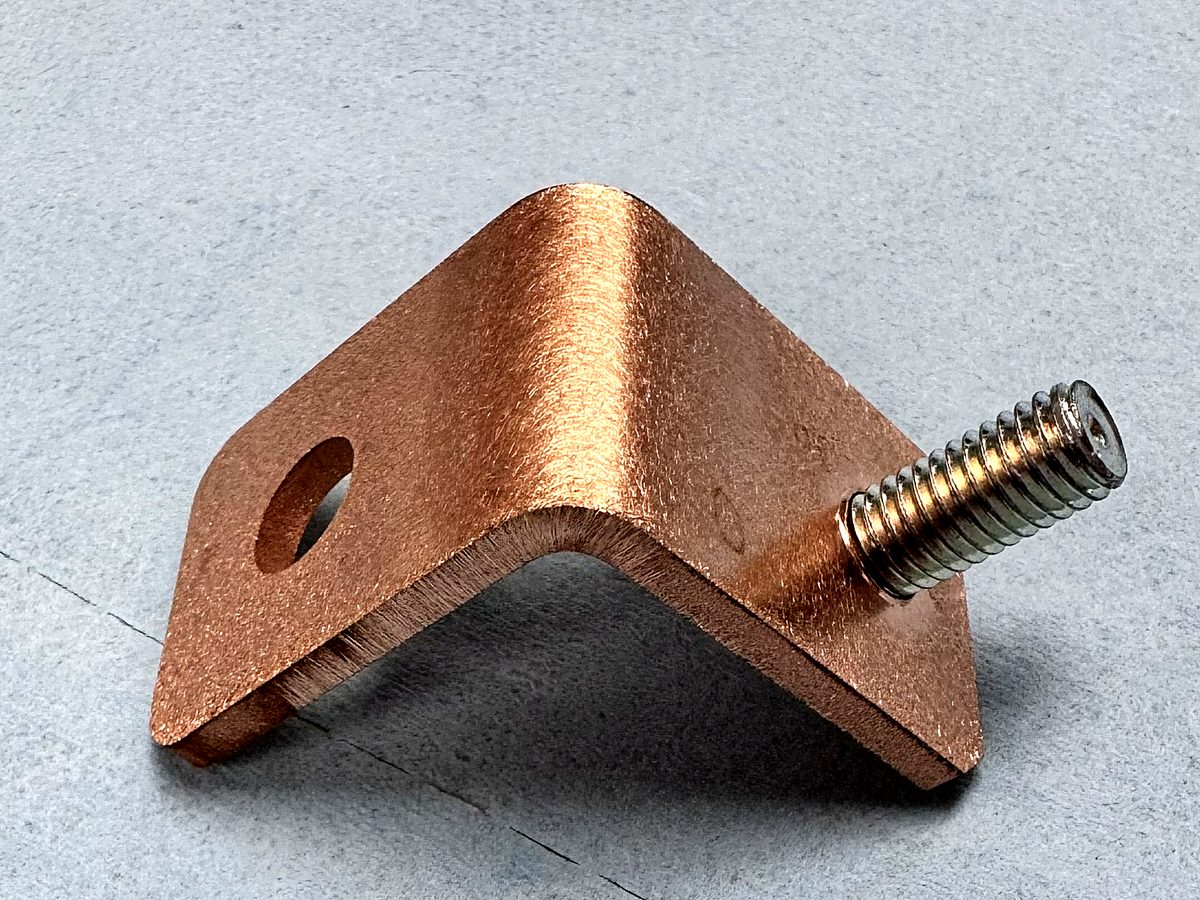 A copper bracket with a pressed in stud at ACP Waterjet