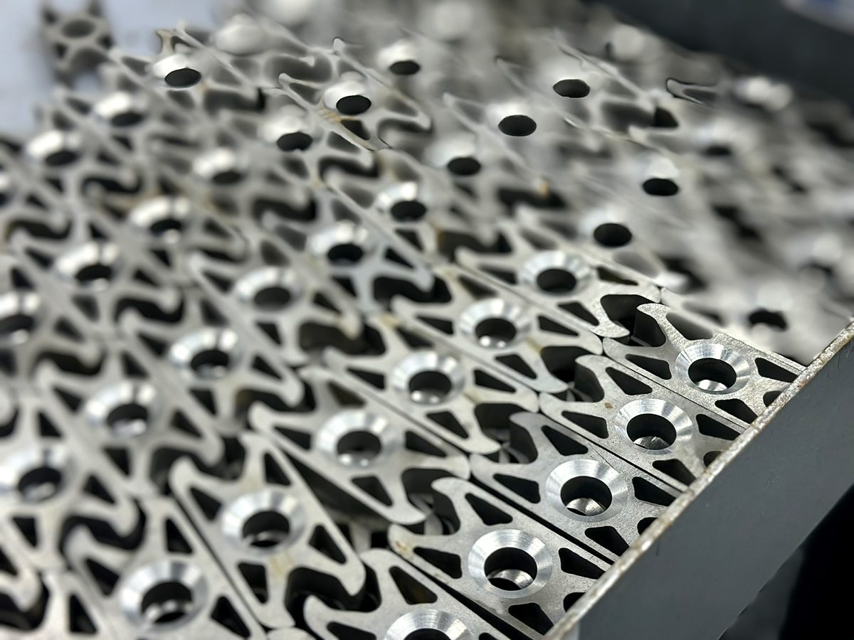 Parts with countersunk holes in a bin at ACP Waterjet