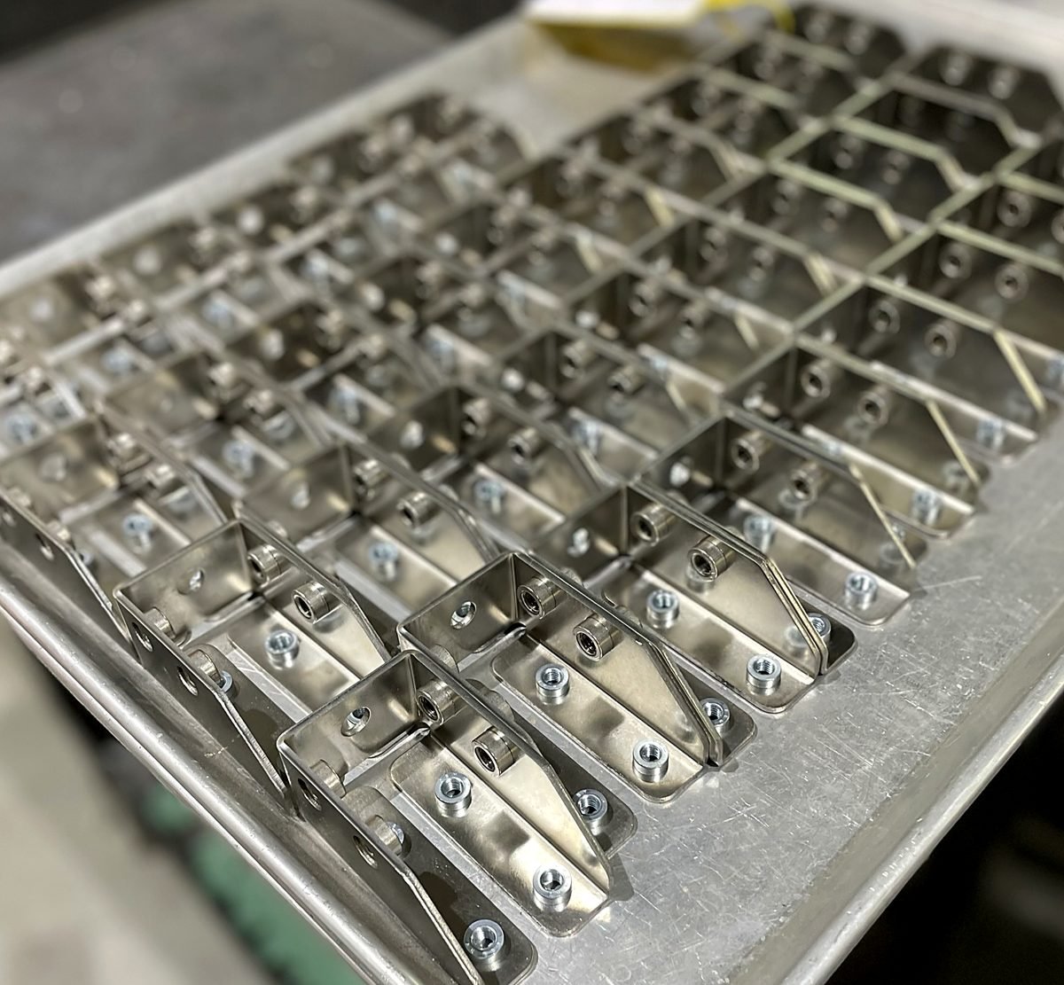 Tray of cut, bent and hardware inserted sheet metal parts ready to ship from ACP Waterjet