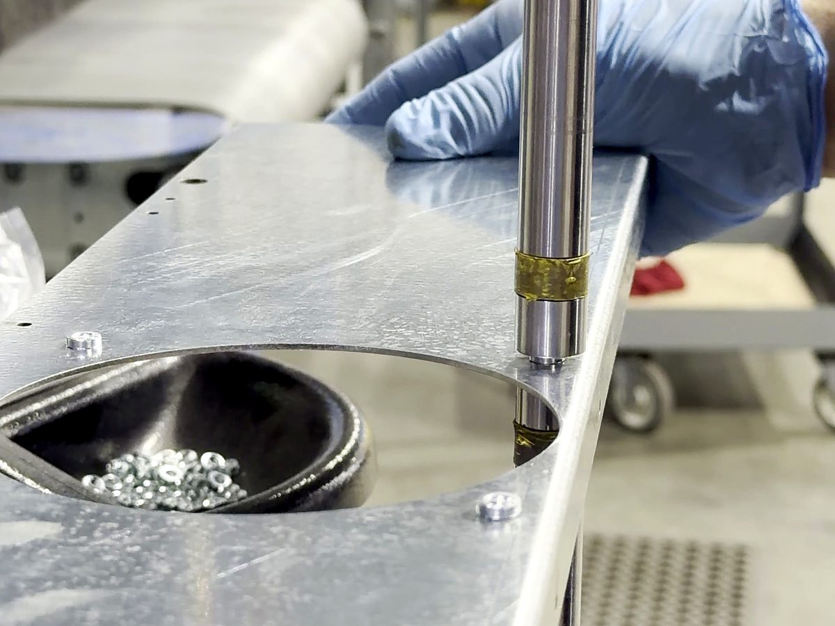 A bowl of press in fasteners at the anvil of the ACP hardware insertion press
