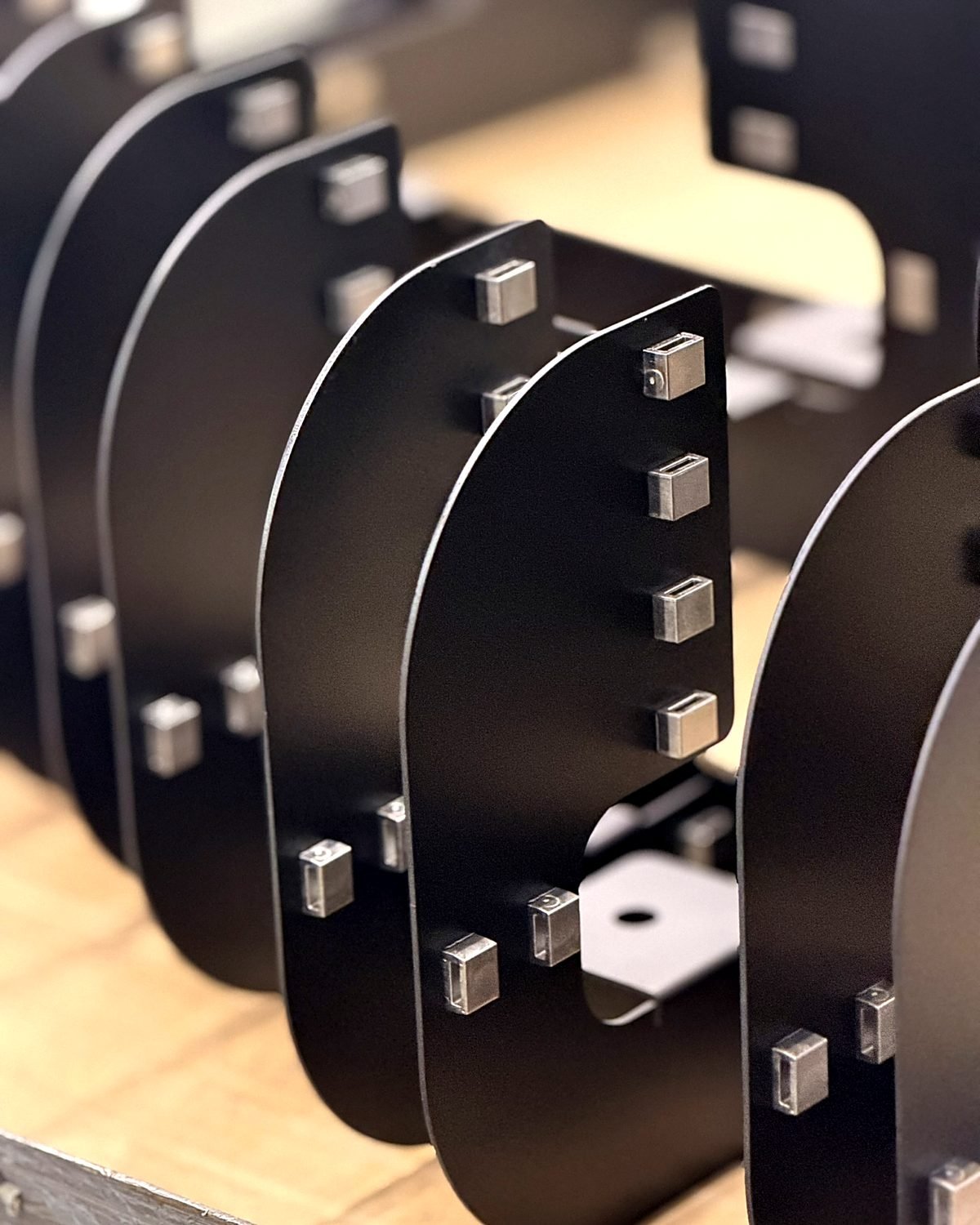 Black sheet metal panels with press in standoffs inserted at ACP Waterjet