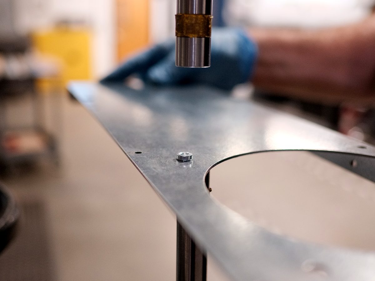 Studs pressed into an aluminum panel at the insertion press anvil at ACP Waterjet