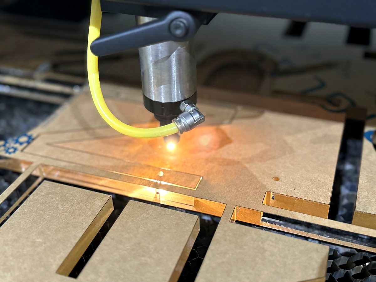 The Kern CO2 laser head cutting acrylic at ACP Waterjet