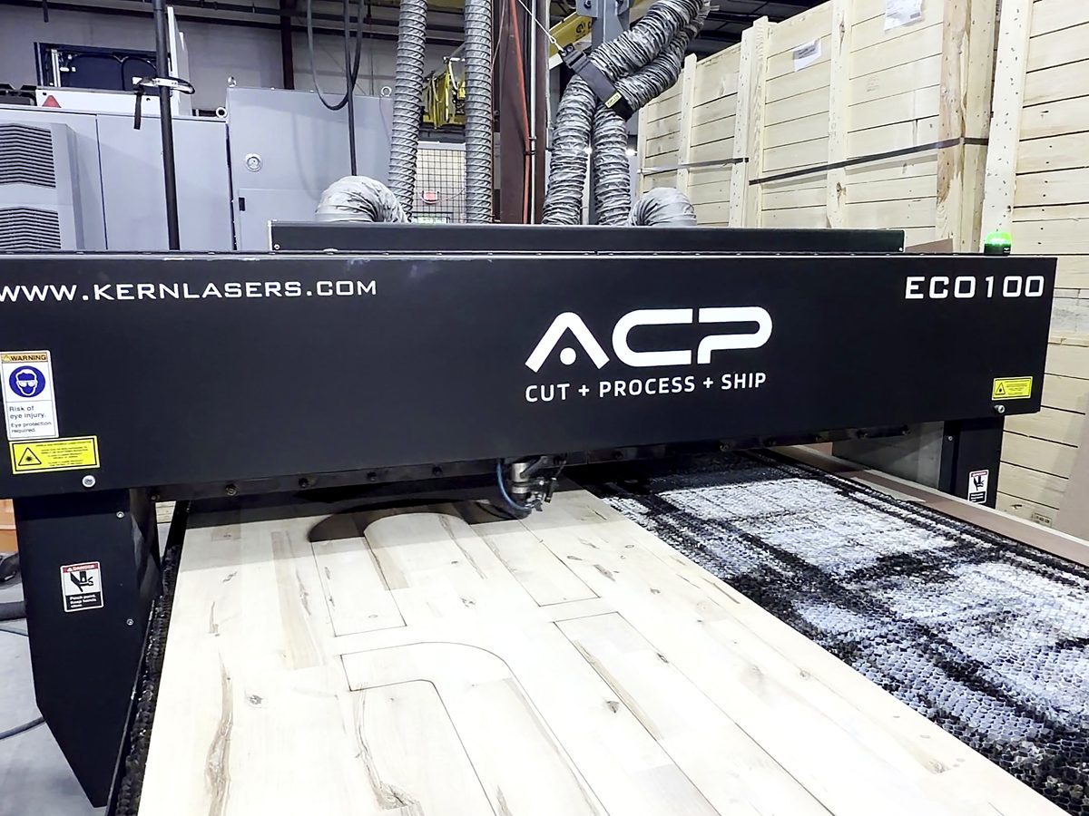 The ACP branded Kern ECO100 laser gantry cutting a board at ACP Waterjet