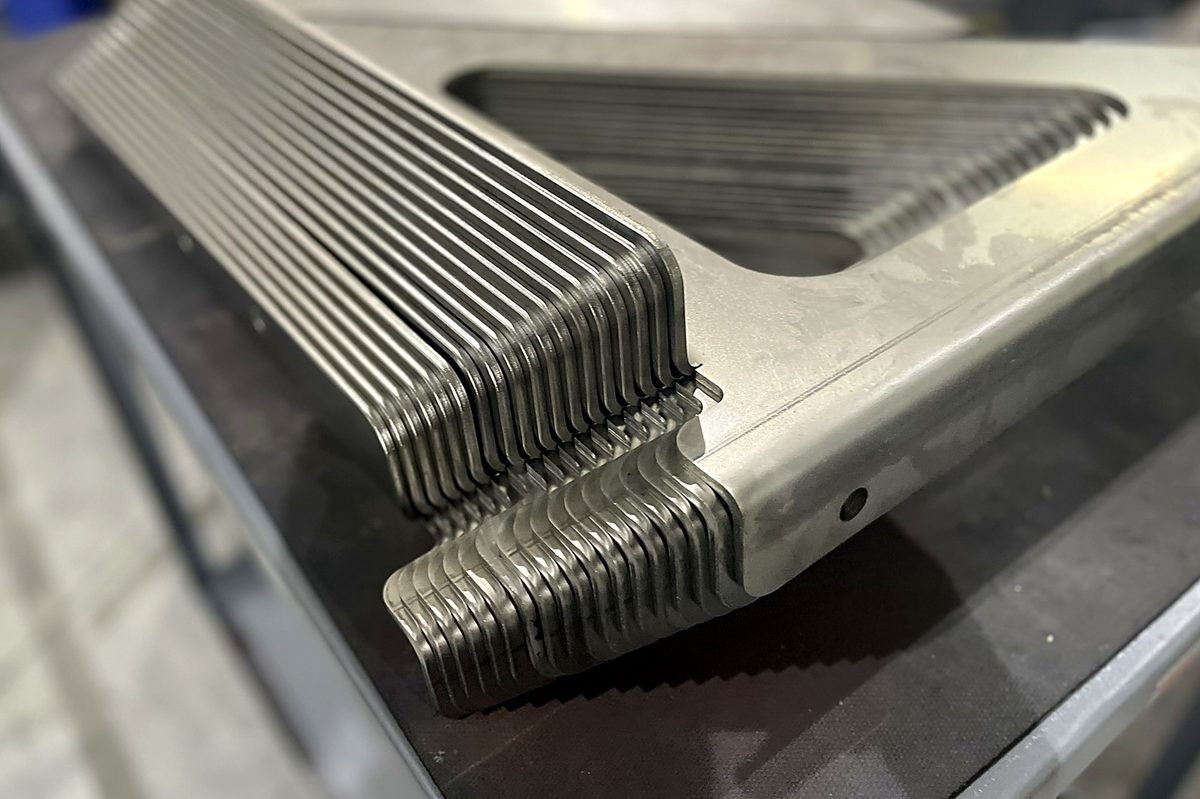 Fanned stack of identical stainless steel parts formed on the press brake at ACP Waterjet
