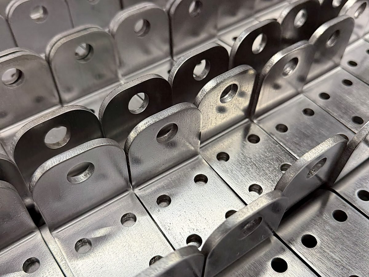 Rows of formed steel brackets with consistent flanges at ACP Waterjet