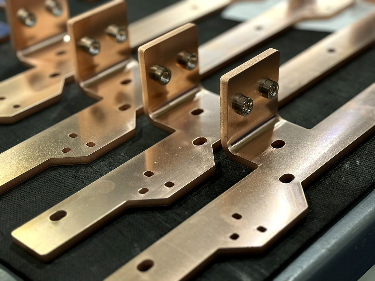 Thick copper bus brackets fitted with steel hardware at ACP Waterjet