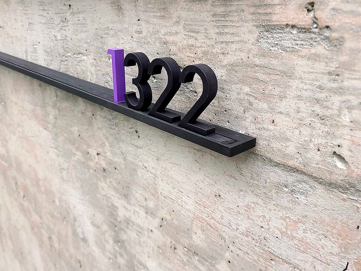 Black cut wayfinding numerals mounted on concrete, made at ACP Waterjet